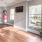 a room with a wood floor and a window with balloons