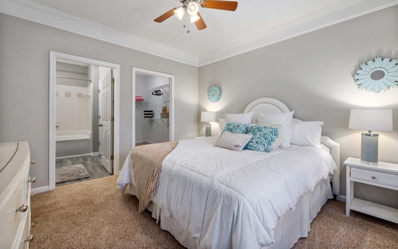 a bedroom with a fan and a bed